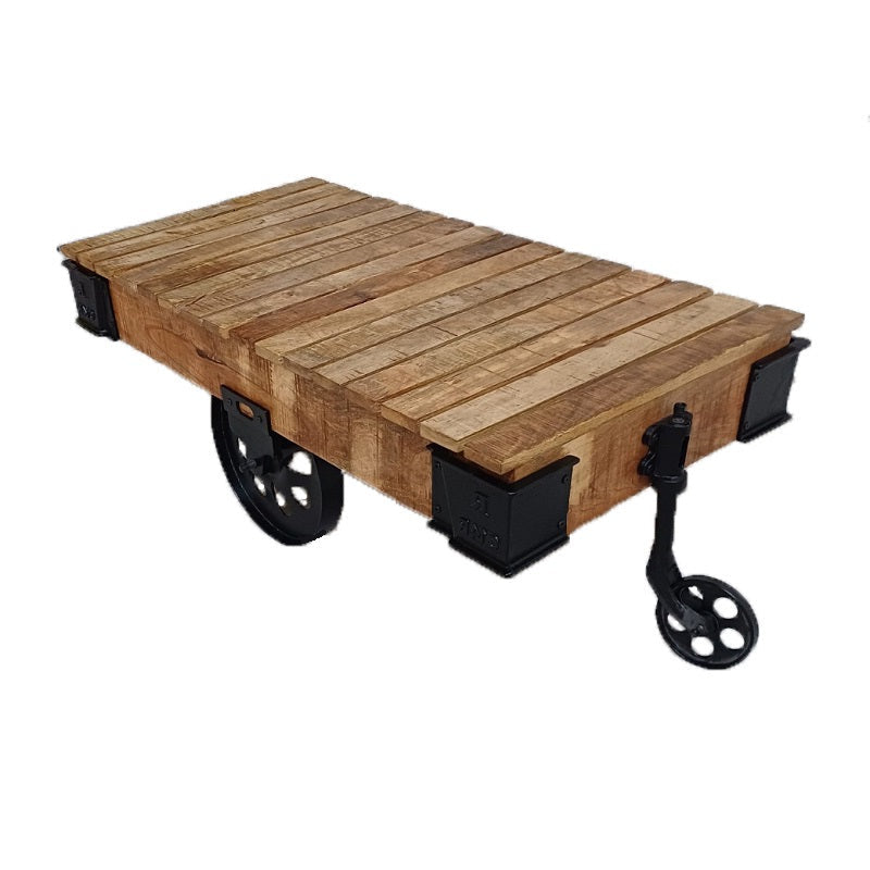 De massief mango houten salontafel Feline is makkelijk te verplaatsen door zijn grote stalen wielen.